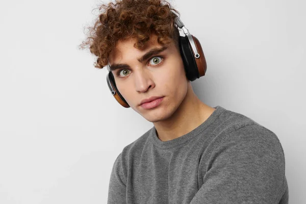 Stylish guy listening to music in headphones emotions light background — Stock Photo, Image