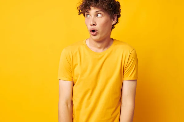 Jovem homem de cabelos encaracolados vestindo elegante camiseta amarela posando Estilo de vida inalterado — Fotografia de Stock