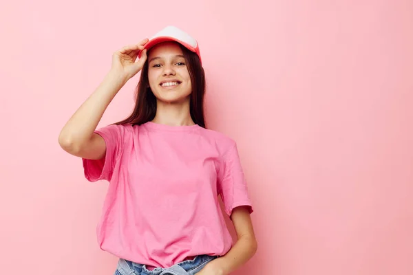 Muchacha joven en una camiseta rosa con una gorra en la cabeza ropa casual — Foto de Stock