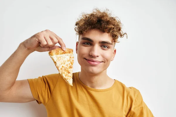 魅力的な男で黄色のtシャツ食べるピザライフスタイル変更なし — ストック写真