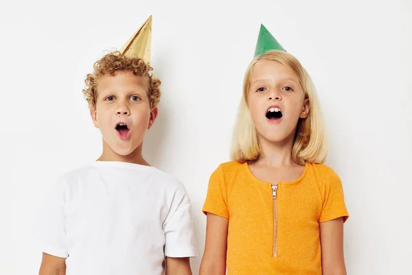Мальчик и девочка, представляющие эмоции праздник красочные колпачки изолированный фон без изменений — стоковое фото