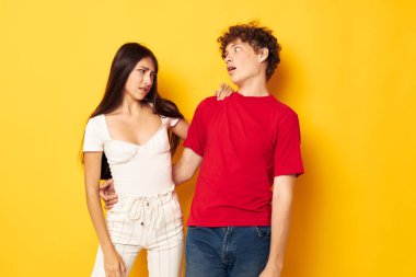 Sevimli, genç bir çift. Sarılıp sarılıyorlar. Sarı arka plan değişmemiş.