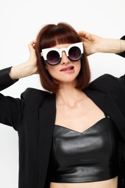 Güneş gözlüklü bir kadının portresi. Deri bir takım elbise. Siyah ceket.