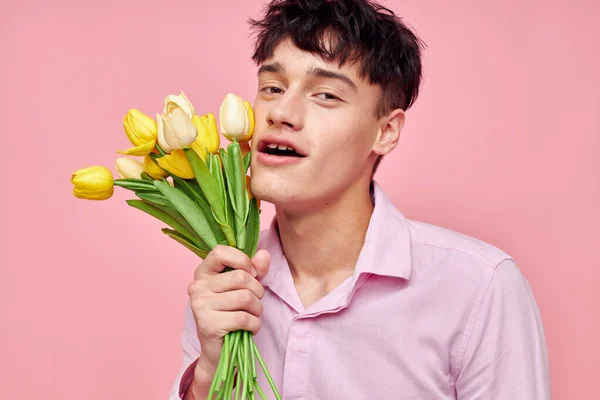 Portrét mladého muže kytice květin datum romantika pózování růžové pozadí beze změny — Stock fotografie