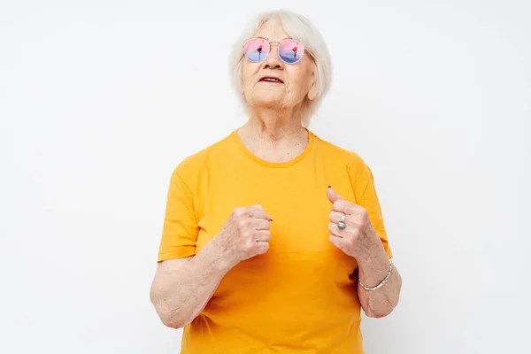Starší žena ve žlutém tričku pózující zblízka emoce — Stock fotografie