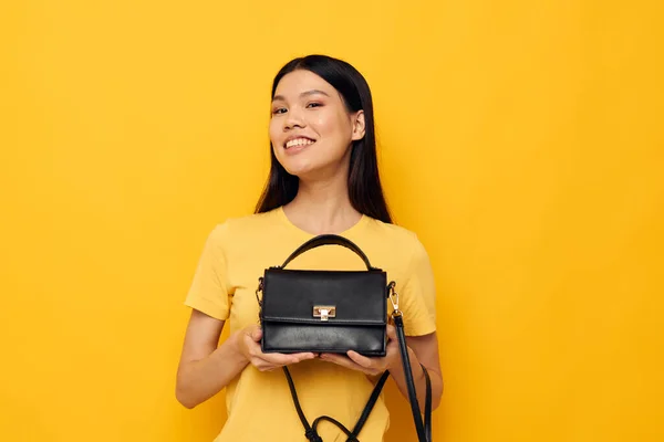 Encantadora joven mujer asiática en camisetas amarillas moda posando accesorio femenino fondo amarillo inalterado —  Fotos de Stock