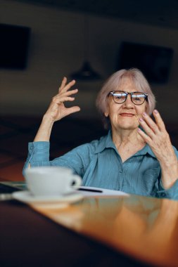 Laptop monitörünün önünde çalışan yaşlı kadın yazlık sosyal ağlarda değişmeden oturuyor.