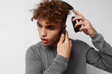 Elinde telefon olan, kulaklıkla müzik dinleyen garip bir adam.