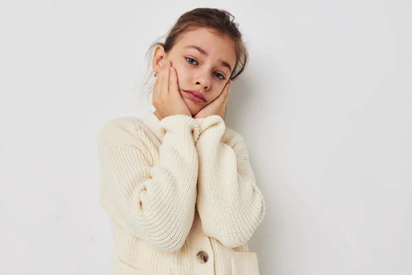 Little girl posing in a white sweater light background — Stockfoto