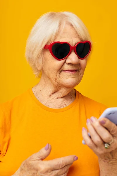 원문 기사보기 은퇴 한 할머니가 일상적으로 티셔츠를 입고 통화하는 모습을 찍은 사진. — 스톡 사진
