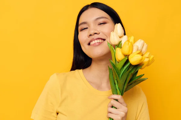 손에 꽃다발을 들고 있는 젊은 아시아 여인을 매혹시키면 아무런 변화 없이 노란 배경을 그리는 즐거움 이 있다 — 스톡 사진