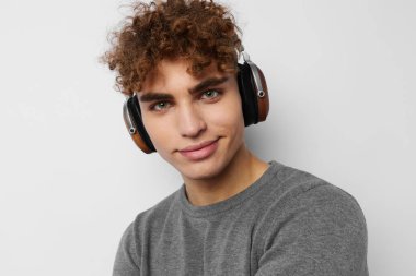 Gri süveter kulaklıklı yakışıklı adam. Moda arkaplanı.