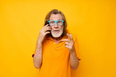 Telefon duyguları sarı arka planda gri sakallı yaşlı adam iletişimi