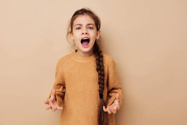 Malá dívka dlouhý copánek béžový svetr grimasa dětství beze změny — Stock fotografie