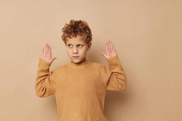 Netter kleiner Junge in einem beigen Pullover posiert Spaß Kindheit unverändert — Stockfoto