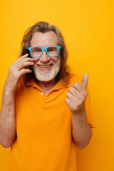Homme âgé barbe grise communication sur le téléphone émotions fond jaune — Photo