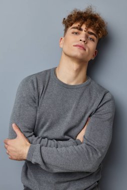 Gri kazaklı çekici bir adam. Moda stüdyosu izole edilmiş.