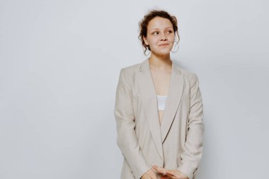 Hafif takım elbiseli neşeli bir kadın el hareketi hafif arka planda değişiklik yok.