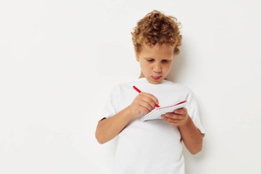 Çocuk, defter eğlence stüdyosunda kalemle resim çiziyor.