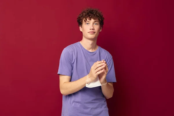 紫のTシャツを着た若い男医療マスクで手の安全赤の背景変更なし — ストック写真