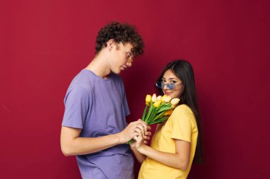 Sevimli genç çift çiçek buketi eğlenceli kırmızı arka plan değiştirilmemiş