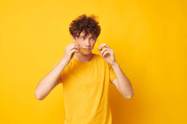 Mladý kudrnatý muž žluté tričko brýle módní ruka gesta černobílý výstřel — Stock fotografie