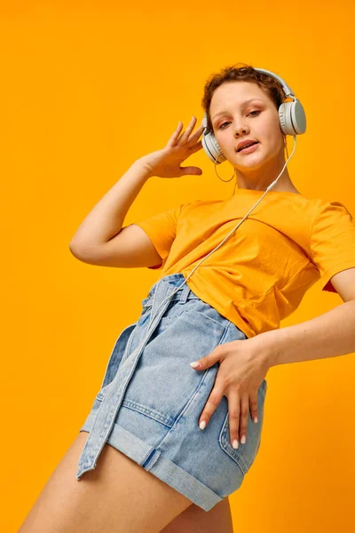 Fröhliche Frau gelbes T-Shirt Kopfhörer Unterhaltung Musik Spaß gelben Hintergrund unverändert — Stockfoto