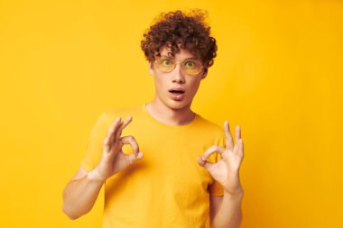 Hoş kızıl saçlı, şık gözlüklü, sarı tişörtlü, hayat tarzını değiştirmemiş biri.