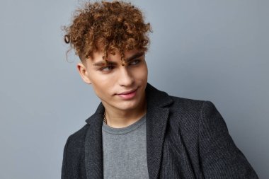 Yakışıklı genç adam seksi poz veren ceketin kendine güveni soyutlanmış arka plan