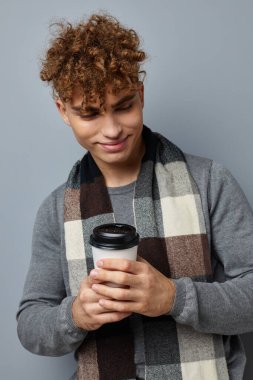 Yakışıklı genç adam gülümsüyor. Eşarplı cam ellerin izole edilmiş.