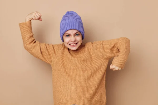 Kislány sapkában és pulóverben pózol — Stock Fotó