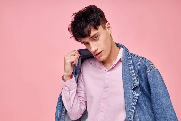 Портрет молодого человека в молодежной стильной джинсовой куртке с неизменным розовым фоном — стоковое фото