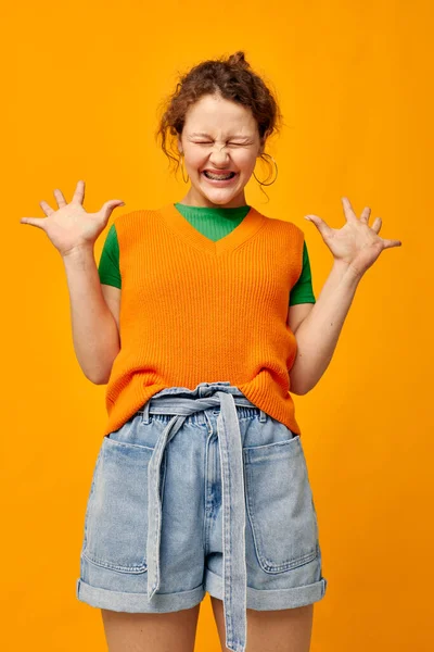 Portrait d'une jeune fille dans un short en denim pull orange — Photo
