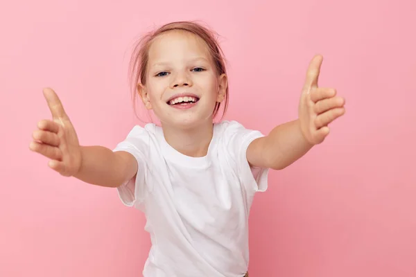 Mała dziewczynka w białym t-shirt uśmiech różowy tło — Zdjęcie stockowe