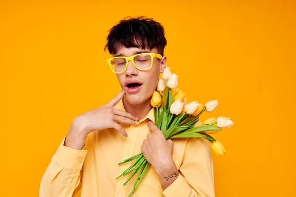 Foto do romântico jovem namorado em óculos amarelos com um buquê de flores Estilo de vida inalterado — Fotografia de Stock