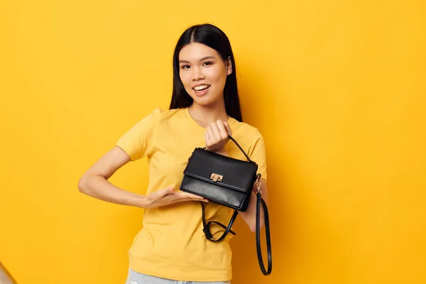 Kvinna med asiatiskt utseende i gula t-shirts mode poserar kvinnliga tillbehör Livsstil oförändrad — Stockfoto