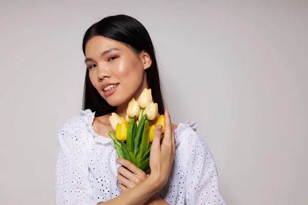 Encantador jovem mulher asiática romance buquê de flores perto do rosto luz fundo inalterado — Fotografia de Stock