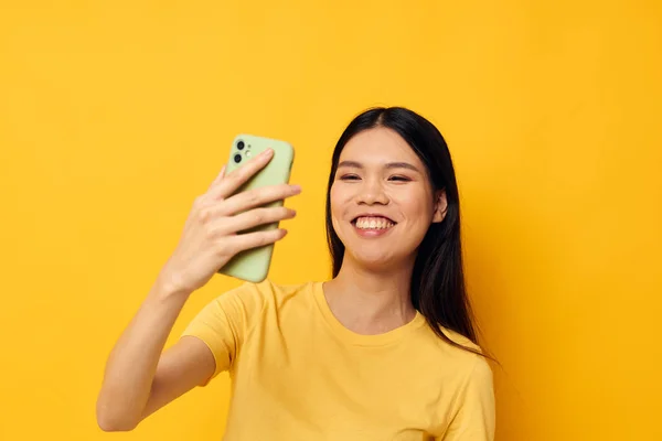 손에 전화기를 들고 젊은 아시아 여성을 공격하는 것은 아무런 변화도 없는 셀카 스튜디오 모델을 만든다 — 스톡 사진