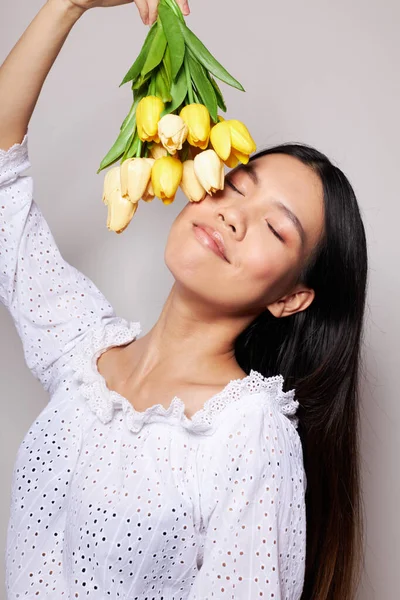 Retrato Asiático bela jovem com um buquê de flores sorriso close-up luz fundo inalterado — Fotografia de Stock