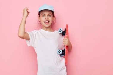 Beyaz tişörtlü küçük kız şapkası kaykay izole edilmiş arka plan