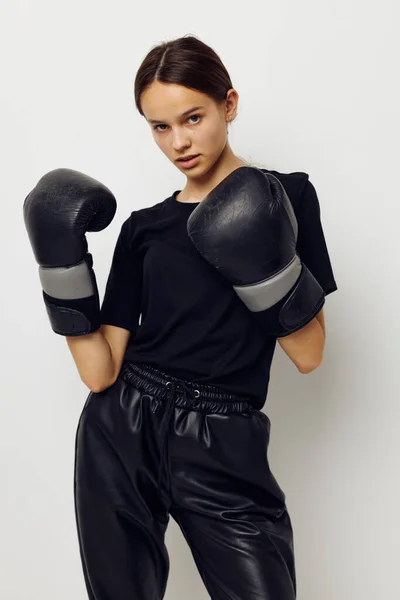 Mujer atlética en guantes de boxeo en pantalones negros y una camiseta de entrenamiento de fitness — Foto de Stock