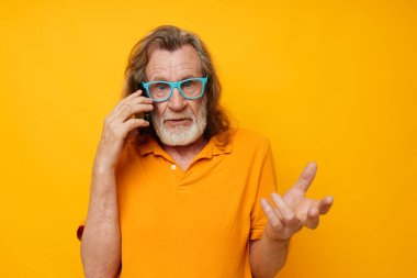 Kıdemli gri saçlı adam telefon duygularında gri sakal iletişimi sarı arka plan