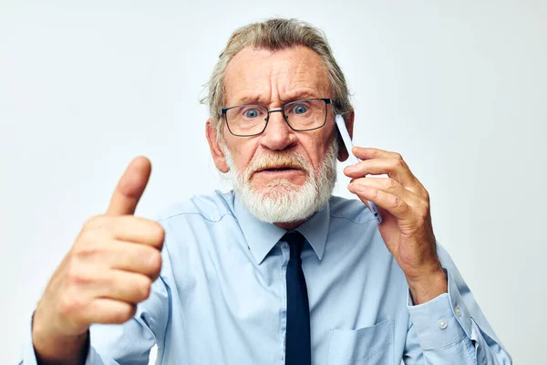 Vieil homme avec téléphone en studio sur fond blanc montre pouce vers le haut — Photo