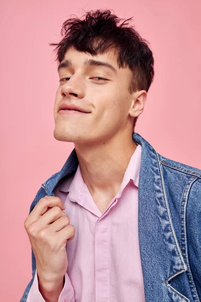 Молодий чоловік зачіска моди позує одяг джинсова куртка сучасного стилю рожевий фон незмінний — стокове фото