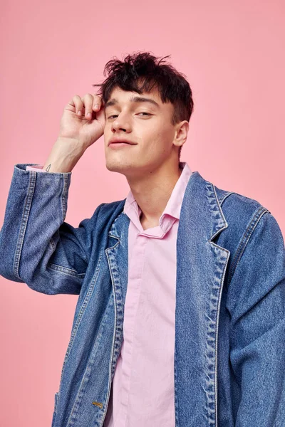 Hübsche Mann in der Jugend stilvolle Kleidung Jeansjacke posiert rosa Hintergrund unverändert — Stockfoto