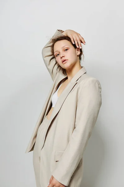 Porträtt av en ung kvinna Kläder passande elegant stil kostym mode studio ljus bakgrund oförändrad — Stockfoto