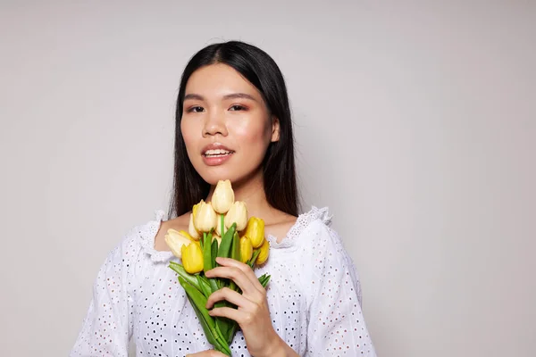 Žena romantika kytice květin v blízkosti obličeje světlo pozadí beze změny — Stock fotografie