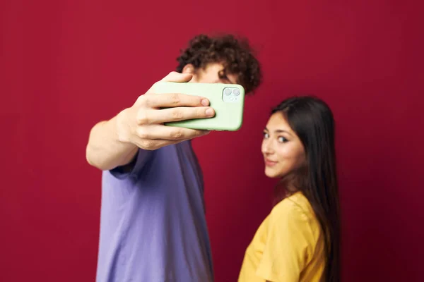 Agradable chico y chica tomar un selfie posando abrazo aislado fondo — Foto de Stock