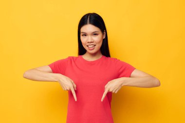 Güzel esmer kırmızı tişörtler modern stil stüdyo modelini değiştirmeden poz veriyor.