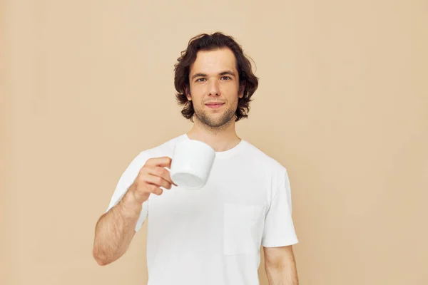 Άνδρας σε λευκό T-shirt με μια κούπα στο χέρι απομονωμένο φόντο — Φωτογραφία Αρχείου